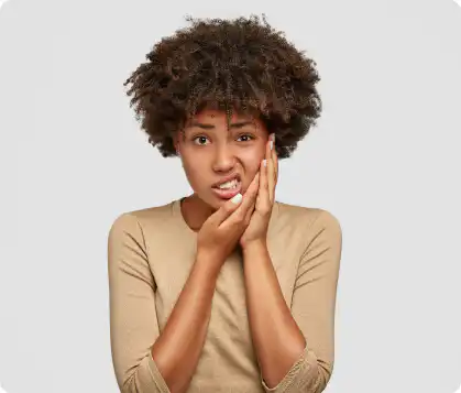 A woman holding her jaw in tooth pain