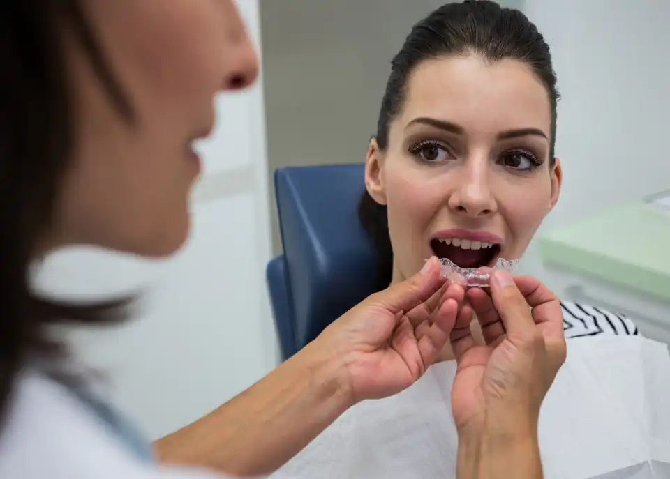 A dentist showing a patient her clear aligner