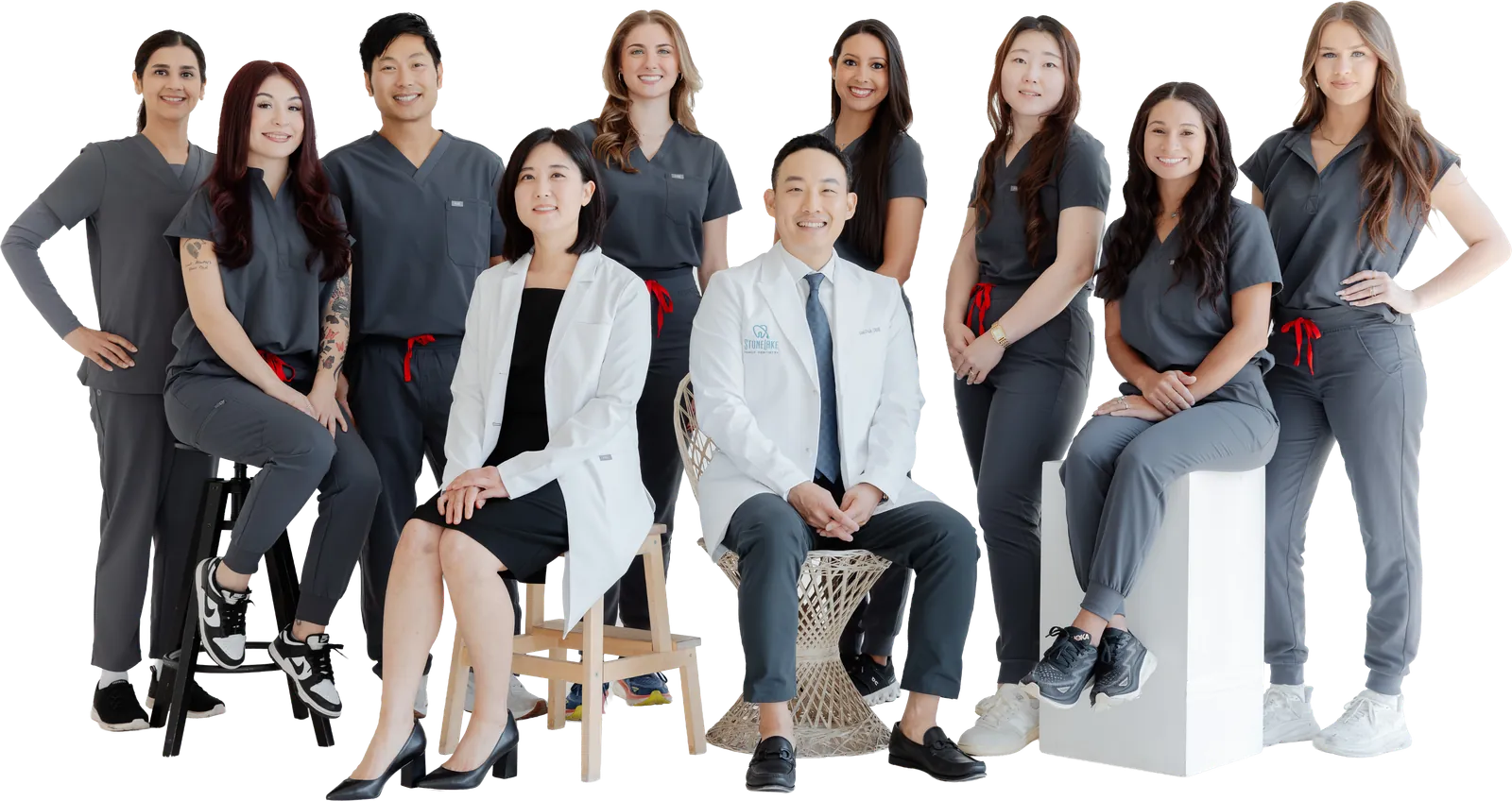 The Stonelake Family Dentistry team: two dentists in white coats seated at the centre, with nine team members in grey scrubs around them